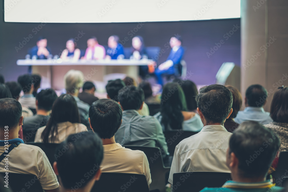 Fototapeta premium Rear view of Audience in the conference hall or seminar meeting which have Speakers are Brainstorming and talking on the stage, business and education about investment concept
