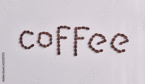 Coffee write with coffee beans on the white table