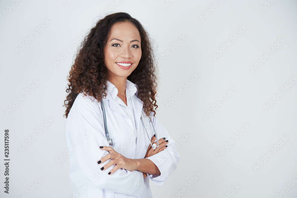 Portrait of beautiful young female doctor in uniform standing with arms crossed Portrait of beautiful young female doctor in uniform standing with arms crossed