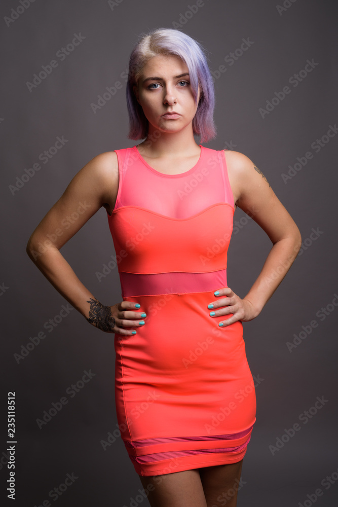 Young beautiful rebel woman with colorful hair against gray back Young beautiful rebel woman with colorful hair against gray back