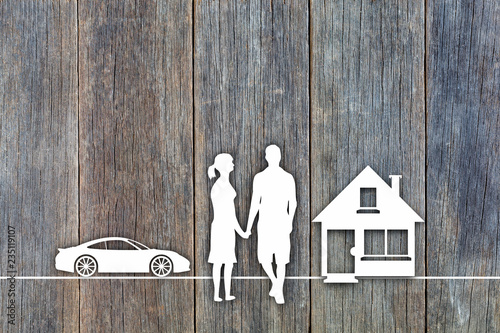 White paper cut concept by silhouette symbols of house, couple and sports car on wooden background in top view concept for assurance health-care insurance photo