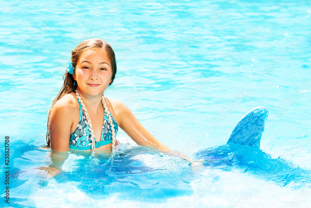 Beautiful mermaid in blue water of swimming pool