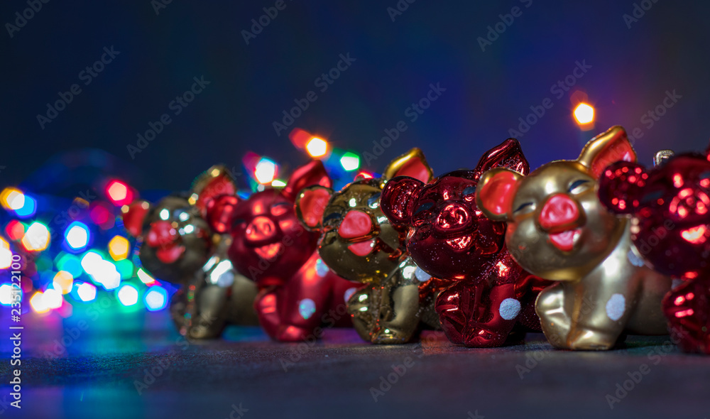 Fototapeta premium Christmas decorations, pigs, against the background of luminous Christmas lanterns