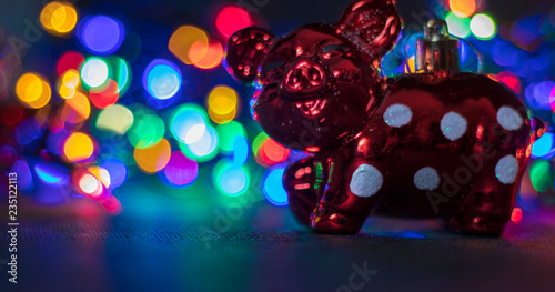 Christmas decorations, pigs, against the background of luminous Christmas lanterns