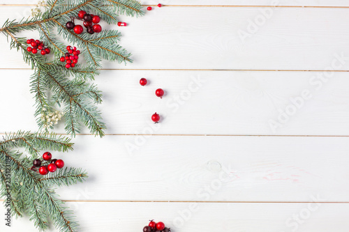 Designers christmas holiday background with eve and red berries on wooden white background. Empty space for text 