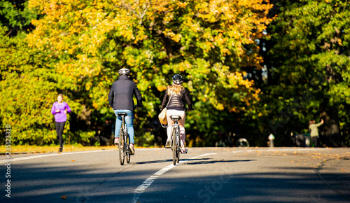 Obraz na płótnie A couple are riding bicycles in the beautiful and colorful Central Park, Manhattan, New York, United States. w salonie