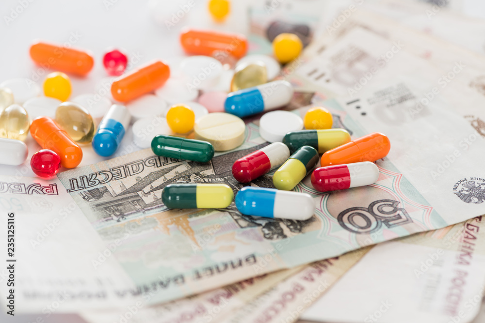 close up shot of colorful various pills and russian cash money on surface close up shot of colorful various pills and russian cash money on surface