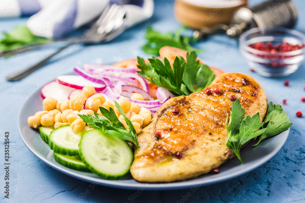 Chicken fiilet grillled, fresh vegetables, chickpeas on blue background.Selective focus, space for text. Chicken fiilet grillled, fresh vegetables, chickpeas on blue background.Selective focus, space for text.