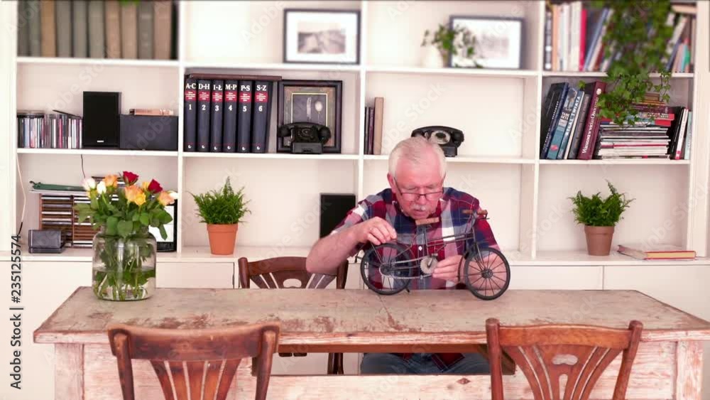 Senior man reparing shelf decoration, by table at home
Senior man reparing shelf decoration, by table at home