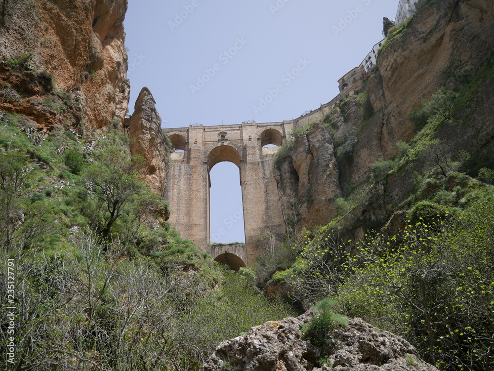 Old bridge connecting two parts of a city on mountains over a canyon in Ronda, Spain