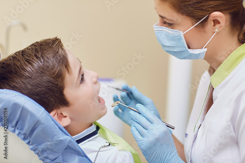 Dentist treats a child s teeth to a boy in a dental office