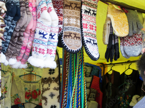 Vests, shirts with patterns, socks, mittens. Holiday trade on the street. © svetlana8art