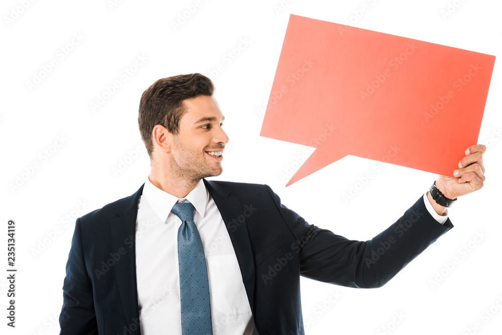 smiling businessman in suit holding empty red speech bubble isolated on white