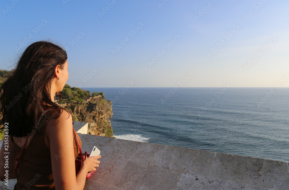 girl stands on a cliff and looks at the sea girl stands on a cliff and looks at the sea