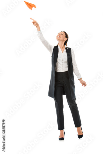 attractive businesswoman throwing paper plane, isolated on white