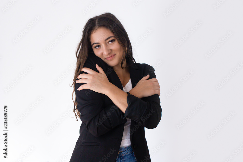 Pretty Caucasian girl hugging shoulders and smiling. Young female student feeling chill in air. Playful girlfriend concept Pretty Caucasian girl hugging shoulders and smiling. Young female student feeling chill in air. Playful girlfriend concept