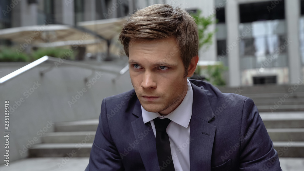 Thoughtful young man sitting on staircase, unsuccessful interview, unemployment Thoughtful young man sitting on staircase, unsuccessful interview, unemployment