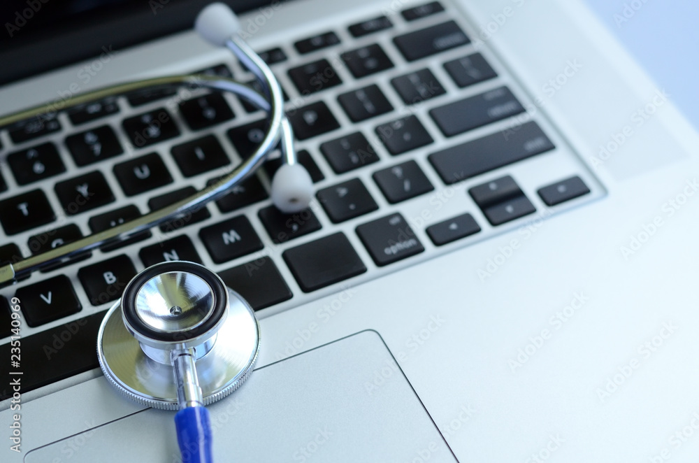 Top view of stethoscope on laptop keyboard Top view of stethoscope on laptop keyboard