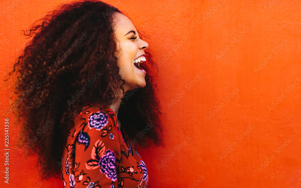Side view of young woman in floral dress laughing Stock-Foto | Adobe Stock