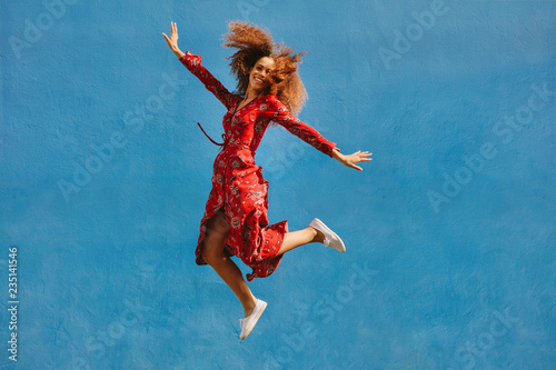 Beautiful woman in sundress jumping with joy