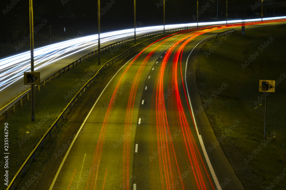 Night traffic on a highway. Passing cars leaving light trails Night traffic on a highway. Passing cars leaving light trails