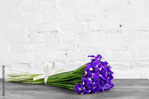 Bouquet of flowers iris lies on a wooden gray table