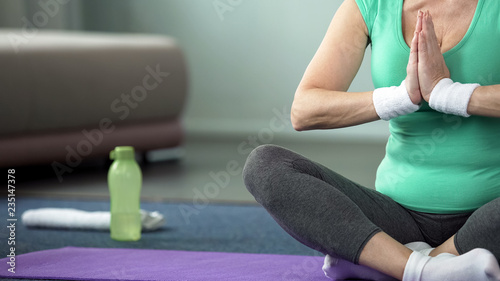 Senior sport lady practicing yoga poses at home, spiritual practice, training
