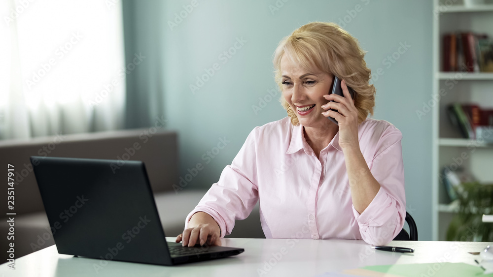 Businesswoman in her 50 calling children during break at work, communication Businesswoman in her 50 calling children during break at work, communication