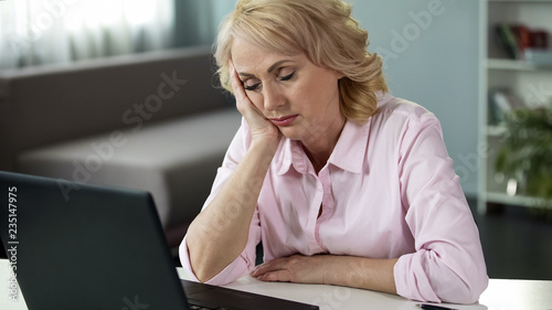 Billede på lærred Mature woman falling asleep at workplace, lack of vitamins and energy, tired