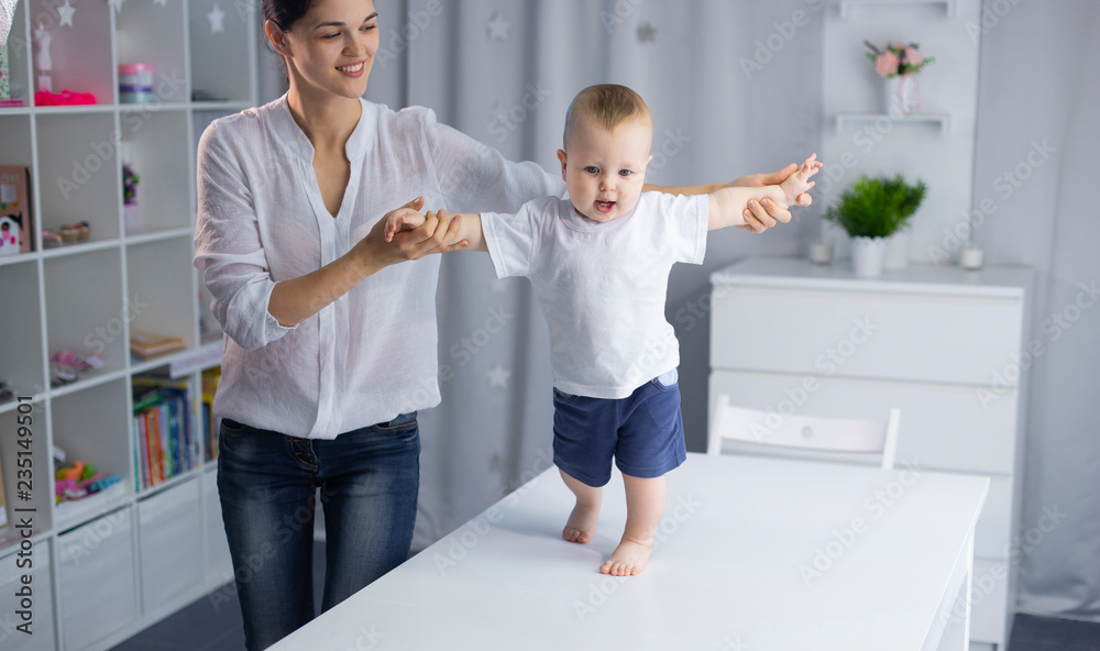 Fototapeta premium baby is learning to take the first steps