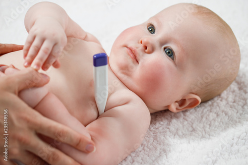 Woman measuring temperature of small sick boy