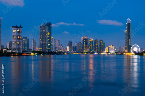 Bangkok city skyline with Chao Phraya river at night during blue hour and famous travel place landmark.