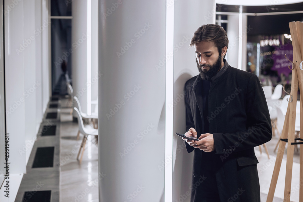 Modern man looking at his smartphone