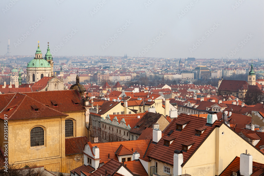 Peaceful view of Mala Strana in Prague with red tiled roofs and the baroque church of Saint Nicholas