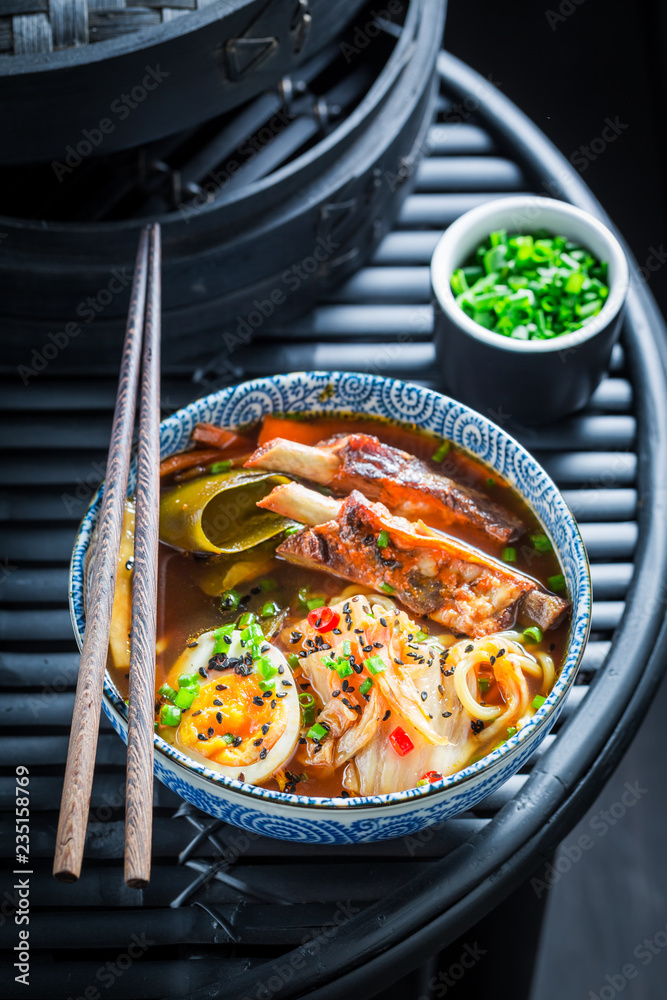 Delicious Kimchi soup with chive and noodles on black table Delicious Kimchi soup with chive and noodles on black table
