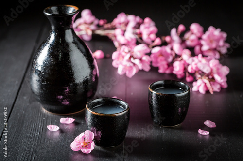 Unfiltered strong sake in black ceramics on dark table