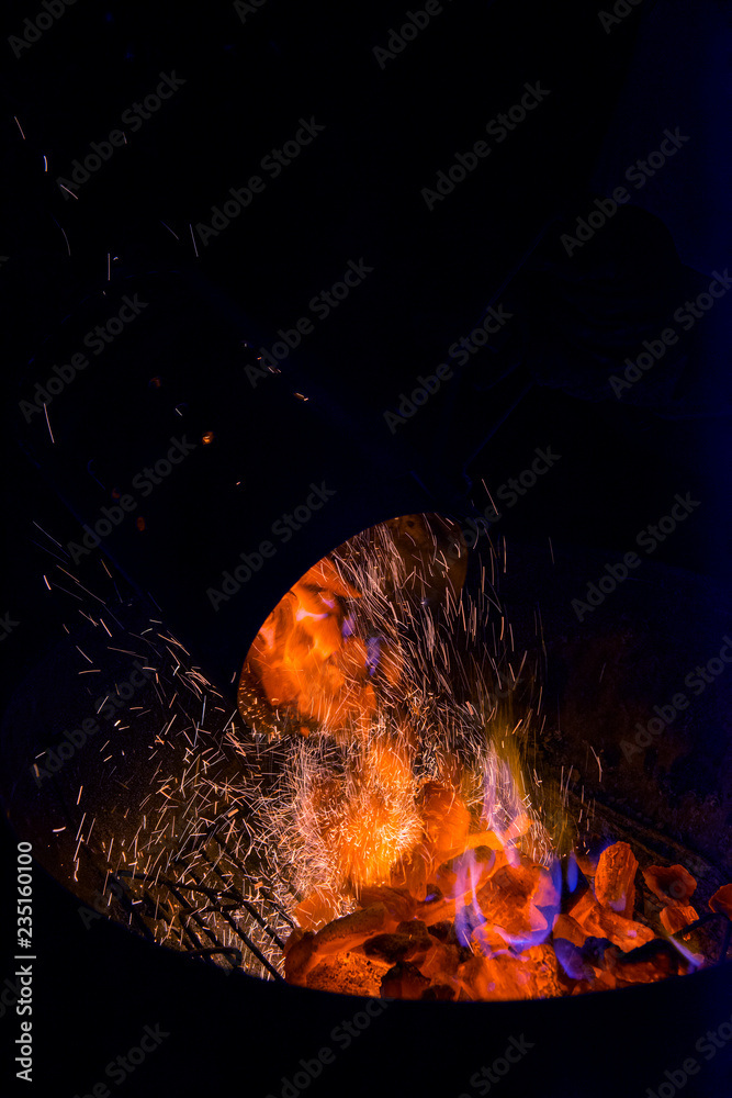 Naklejka premium Pour Charcoal lit in the barbecue