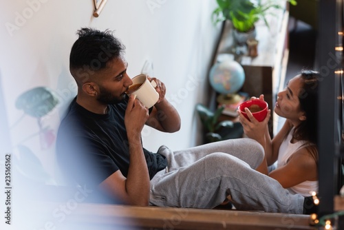 Couple having coffee in stairs at home photo