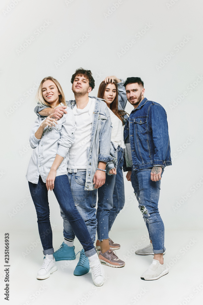 Group of smiling friends in fashionable jeans. The young men and woman  posing at studio. The fashion, people, happy, lifestyle, clothes concept  Stock Photo | Adobe Stock