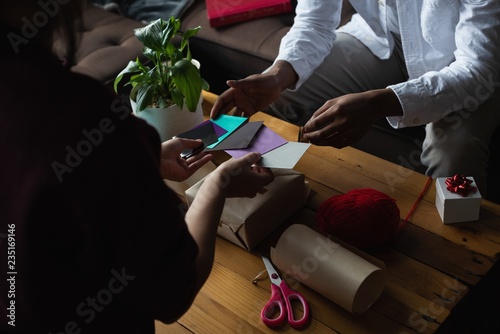 Couple choosing gift tag in living room