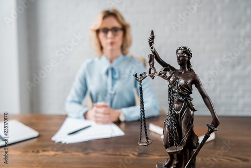 close-up view of lady justice statue and female lawyer working behind