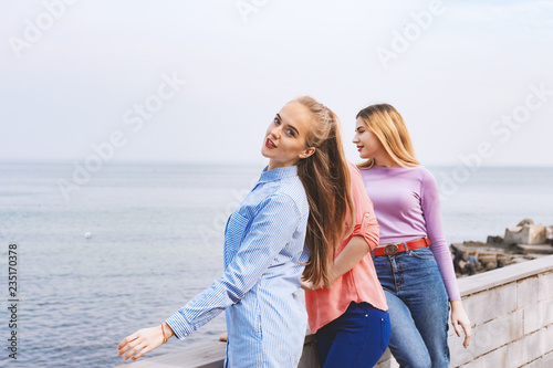 Portrait of three young female friends walking near sea