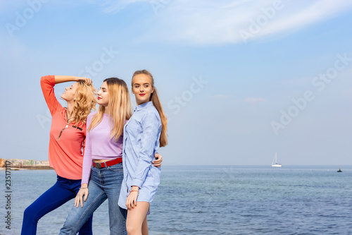 Portrait of three young female friends walking near sea