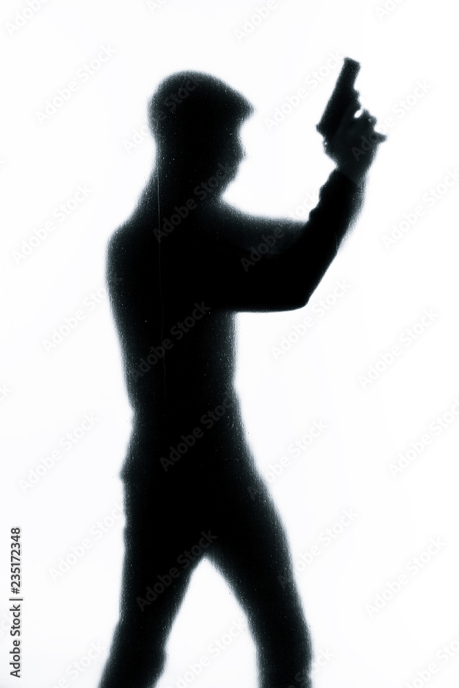 Silhouette of a man holding a gun.