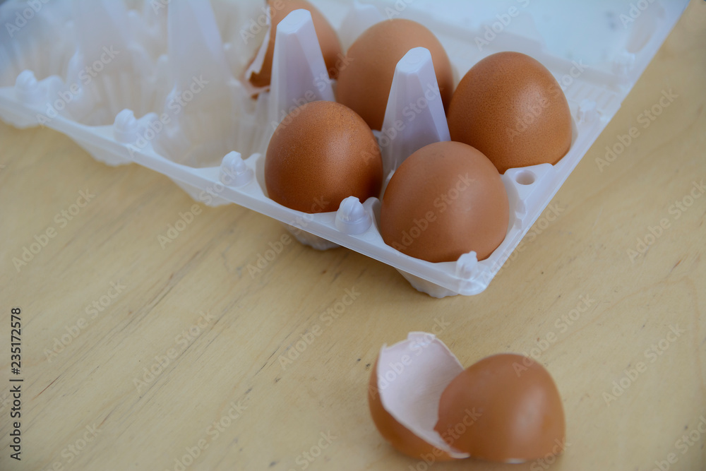 Four eggs in a container above a wooden table Four eggs in a container above a wooden table