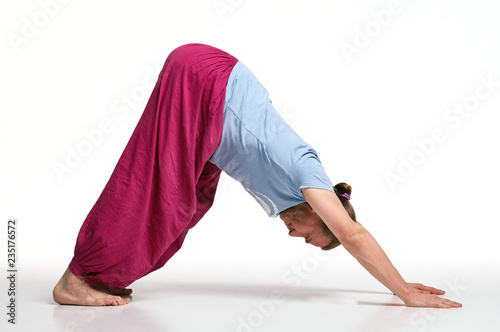 Bearded longhair man practicing yoga. Model doing exercises isolated on white background. Adho mukha svanasana pose (Downward facing dog pose). Full length