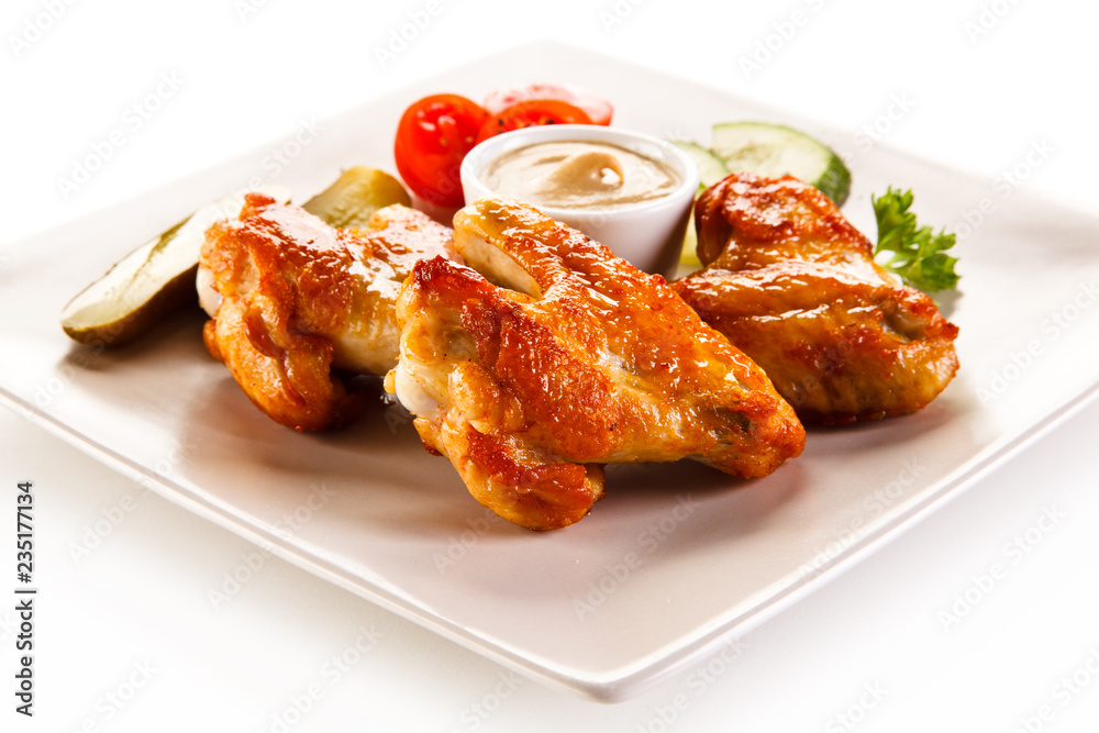 Grilled chicken wings with vegetables on white background Grilled chicken wings with vegetables on white background