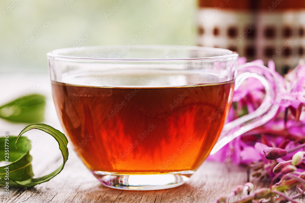 Herbal drink Ivan-tea in a transparent cup close-up on wooden table Herbal drink Ivan-tea in a transparent cup close-up on wooden table