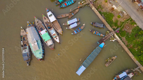 TOP DOWN: Flying along the rural road running past the floating wooden boats. © helivideo