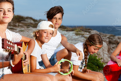 Young music band playing acoustic guitars outdoors © Sergey Novikov